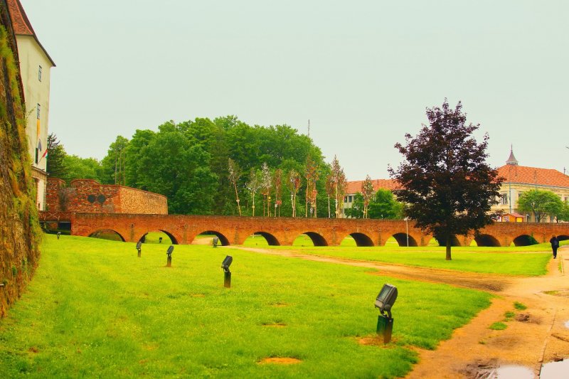 Pohled na cihlový mnohaobloukový most vedoucí na hrad